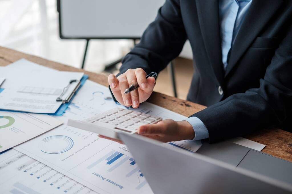 Accountant using calculator for calculate finance report in office.